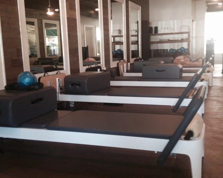 Close-up of the wood accent wall and modern lighting fixtures in the Pilates studio.