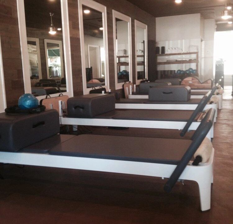 Close-up of the wood accent wall and modern lighting fixtures in the Pilates studio.