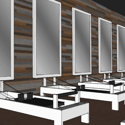 Interior view of the modern Pilates studio with dedicated reformer stations and large mirrors.