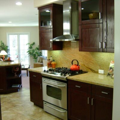 Renovated kitchen featuring dark wood cabinetry and stone countertops